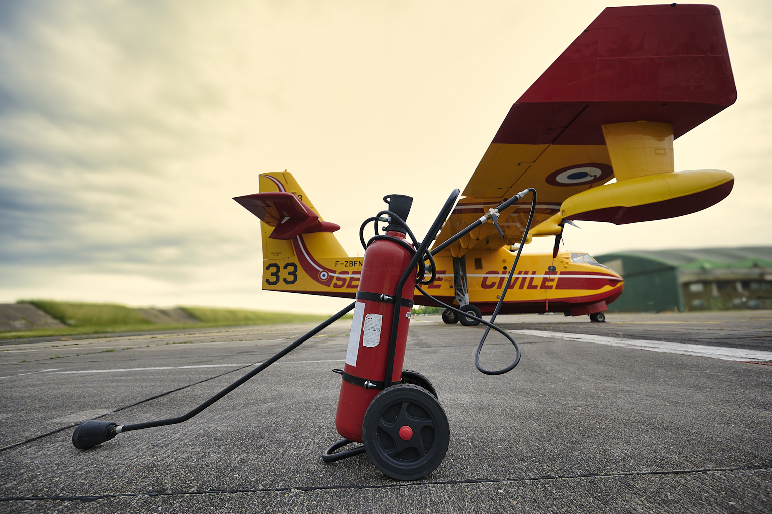 Extincteur de piste, devant u Canadair devant sur un tarmac d'aérodrome.